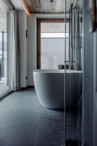 a large bath tub in a bathroom with a window at Biohof Ebengut in Maria Alm am Steinernen Meer