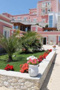 a garden with red and white flowers and buildings at Hotel Boutique Il Castellino Relais in Vieste