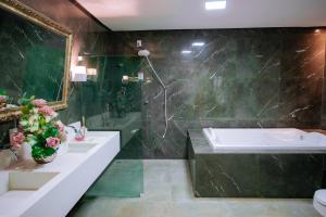 a bathroom with two sinks and a bath tub at Roma Hotel in Bacabal +29 photos