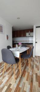 een keuken met een tafel en stoelen in een kamer bij Hermoso apartamento en conjunto cerrado cerca al aeropuerto in Bogota