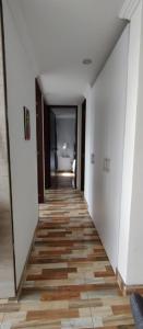 a hallway with white walls and a wooden floor at Hermoso apartamento en conjunto cerrado cerca al aeropuerto in Bogotá