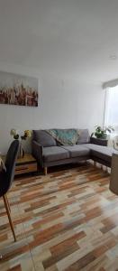 a living room with a couch and a wooden floor at Hermoso apartamento en conjunto cerrado cerca al aeropuerto in Bogotá