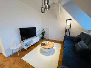 a living room with a blue couch and a tv at ruhig-Nespresso-Netflix-Parken-luxuriös in Wuppertal