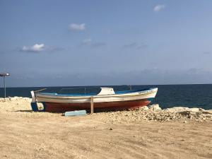 a boat sitting on a beach near the water at Mazotos Panoramic Village in Mazotos