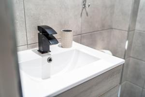 a bathroom sink with a cup on top of it at Modern Studio Apartment with Free Parking in Wolverhampton 5min walk to City Centre in Wolverhampton