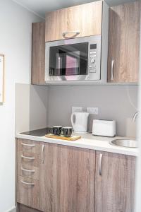 a kitchen with a microwave and a counter top at Modern Studio Apartment with Free Parking in Wolverhampton 5min walk to City Centre in Wolverhampton