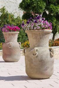 two large vases filled with flowers on a sidewalk at Hotel Boutique Il Castellino Relais in Vieste
