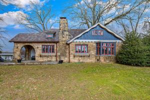 a stone house with a chimney on top of a yard at The Howe House in Nashville