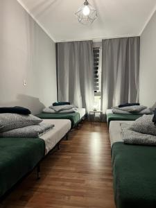 a row of beds sitting in a room at Apartament Nowowierzbowa 16 Zawiercie in Zawiercie