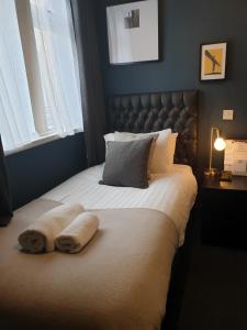 a bed with a blanket and a pillow on it at The Metropolitan Guest House in Whitley Bay