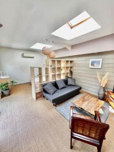 salon z kanapą i stołem w obiekcie Maisonnette de charme aux portes d'Hossegor w mieście Bénesse-Maremne