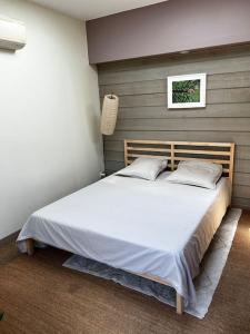 sypialnia z dużym białym łóżkiem w pokoju w obiekcie Maisonnette de charme aux portes d'Hossegor w mieście Bénesse-Maremne