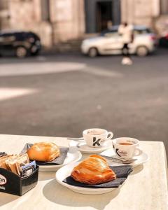 two cups of coffee and croissants on a table at B&B a Capua - I PORTICI del centro in Capua