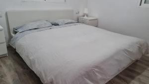 uma cama branca com duas almofadas num quarto em HELLO OLIVA BEACH Bungalow Alto em Oliva