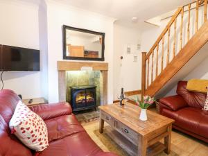 - un salon avec un canapé et une cheminée dans l'établissement Poppy Cottage, à Ashbourne