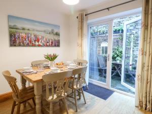 a dining room with a table and chairs and a window at Poppy Cottage in Ashbourne