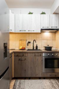 a kitchen with white cabinets and a sink at Holiday Home By The Sea--Bougainvillea in Ston