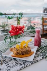 a plate of food on a table next to a vase at Palm Hotel Tarapoto in Tarapoto