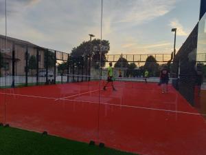 un grupo de personas jugando al tenis en una pista de tenis en Residenza Le Querce Trilocale, en Fossato di Vico