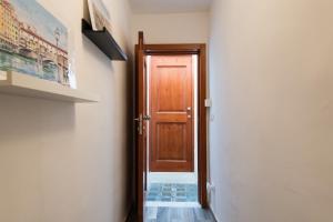 a hallway with a wooden door in a room at Centrale APT con terrazza a 5min dal Pitti! - HomeUnity in Florence