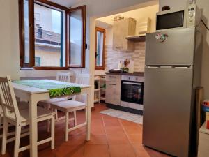 a kitchen with a table and a refrigerator at Il Rustico Moderno del Centro di Portoferraio - Goelba in Portoferraio