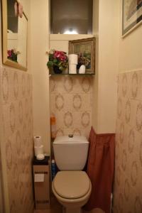 a small bathroom with a toilet and flowers on a shelf at Residence Privée in Nice