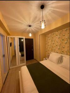 een slaapkamer met een groot bed en een muur met bloemen bij Vere Corner Hotel in Tbilisi City