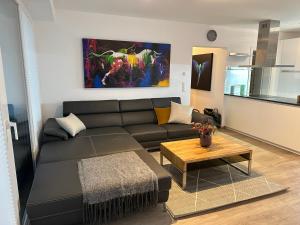 a living room with a black couch and a table at Ferienwohnung Fischerweg in Bodensdorf