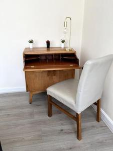 a desk with a white chair next to a wooden desk at Winter Gardens North Pier Home in Blackpool