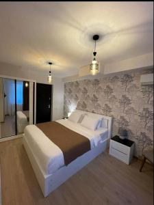 een slaapkamer met een groot wit bed en een muur bij Vere Corner Hotel in Tbilisi City