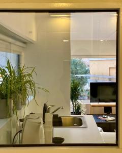 a kitchen with a sink and a window with plants at Mosaikon Guesthouses #Aiolou Str in Athens