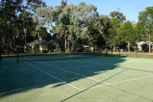 a tennis court with a net on it at Perfectly Located Complete Villa in Pokolbin