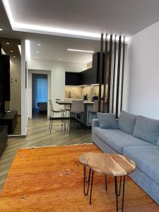 uma sala de estar com um sofá azul e uma mesa em Luxury Apartment em Akrata