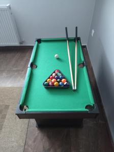 a green pool table with cue balls and cue sticks at Nad Lasem in Bukowina Tatrzańska