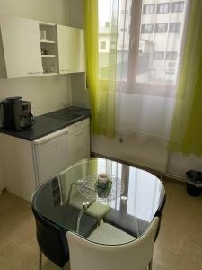 una pequeña cocina con mesa de cristal y sillas blancas. en Top-Apartment en Mürzzuschlag