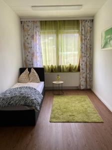 a bedroom with a bed and a window with a green rug at Top-Apartment in Mürzzuschlag