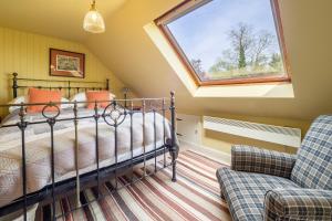 a bedroom with a bed and a window and a couch at Vibrant rural hideaway - Aspen Loft in Sudbury