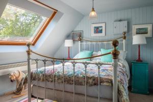 a bedroom with a bed with a dog standing next to it at Vibrant rural hideaway - Aspen Loft in Sudbury