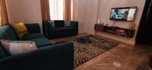 a living room with two blue couches and a television at Remarkable 2-Bed Apartment Dar el Salam Tanzania in Dar es Salaam