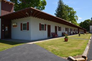 a small white building with a red roof at The Village Motel in Richfield Springs