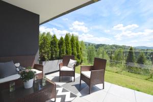 a patio with chairs and a table with a view at Apartament Na Bukowej - Wisła, widokowe studio in Wisła