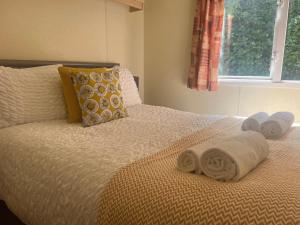 Gold 10 - Cornish Coastal Retreats في Saint Hilary: غرفة نوم عليها سرير وفوط