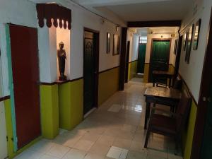 pasillo con puertas coloridas, mesa y sillas en Soben Cafe Guesthouse & Restaurant en Siem Reap