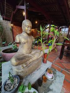 una estatua de un hombre sentado en un banco en Soben Cafe Guesthouse & Restaurant en Siem Reap