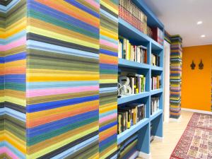 una biblioteca colorida con una pared de libros en La Favorita - Ben collegato con l'aeroporto, la spiaggia di Mondello e il centro città, en Palermo