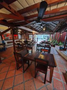un restaurante con mesas de madera y sillas en una habitación en Soben Cafe Guesthouse & Restaurant en Siem Reap