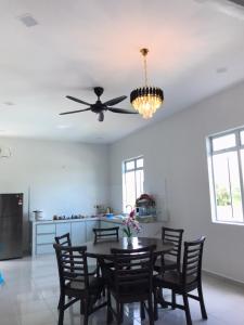 a dining room with a table and a ceiling fan at Homestay Bendang Hilir in Kuala Nerang