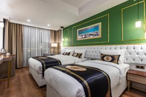 2 camas en una habitación de hotel con paredes verdes en GRAND HAMİT By Karadayı Airport Hotel en Arnavutköy