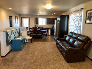 Il comprend un salon avec un canapé en cuir et une cuisine. dans l'établissement Dakota Ridge, à Rapid City