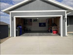 un garage avec une porte de garage ouverte dans une maison dans l'établissement Dakota Ridge, à Rapid City